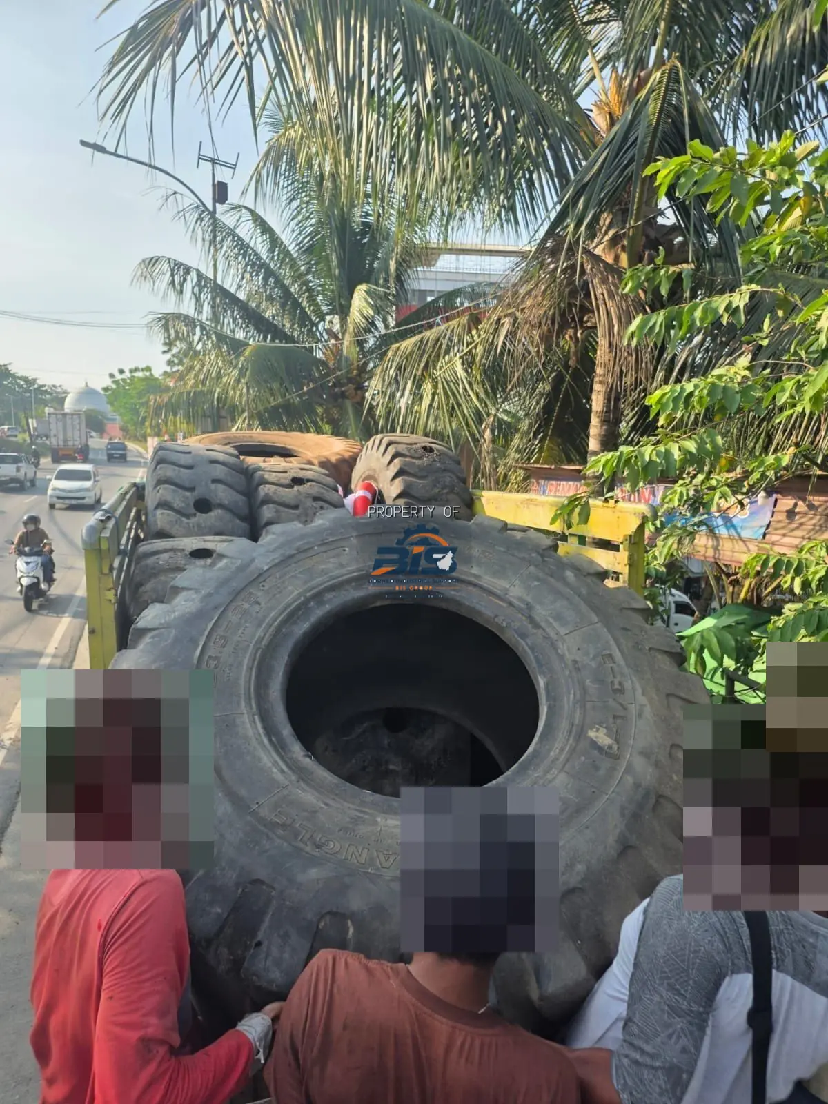 Pemuatan ban dapra alat berat ke truk untuk pengiriman, wajah pekerja disamarkan